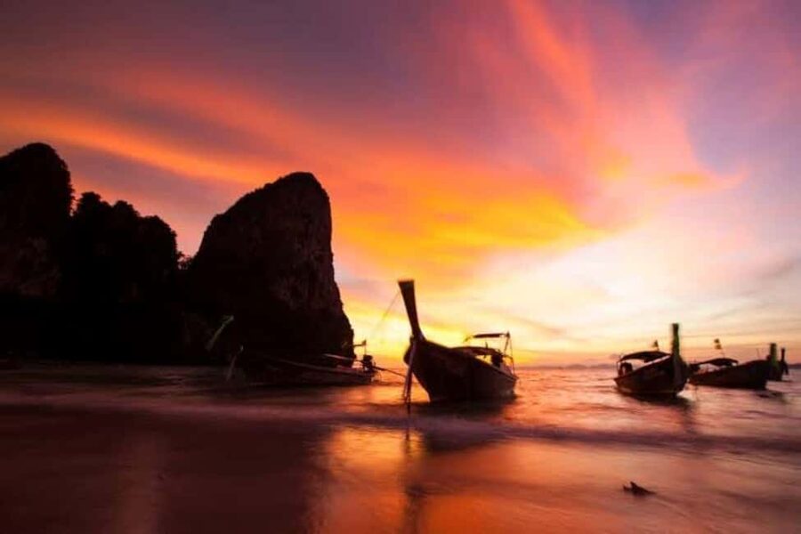 Krabi: Railay Sunset and Bioluminescent Plankton Tour - Riding a traditional longtail boat to Railay